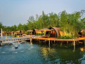 a luxury resort with a pond and a spa at Khum Damnoen Resort in Ratchaburi