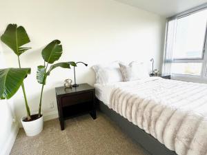 a bedroom with a bed and two potted plants at Sunlit Lakeside Oasis in Oakland