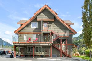 Squamish Adventure Inn في سكواميش: منزل على الشرفة كرسيين