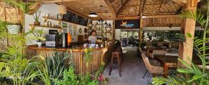 a woman standing at a bar in a restaurant at Isola del Sole Villas and Resort in General Luna