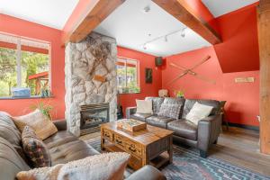 Squamish Adventure Inn في سكواميش: غرفة معيشة مع جدران حمراء ومدفأة حجرية