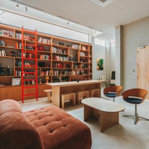 uma sala de estar com um sofá, uma secretária e estantes em อาทิตย์ รีสอร์ท เกาะล้าน em Ko Larn