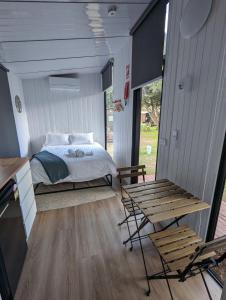 a bedroom with a bed and a table and chairs at Tiny House 2 at Grampians Edge in Dadswells Bridge