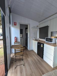 a small kitchen with a table and a microwave at Tiny House 2 at Grampians Edge in Dadswells Bridge