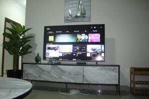 duży telewizor z płaskim ekranem siedzący na stole w obiekcie Your home away from home w mieście Lusaka