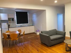 Glenelg Holiday Apartments-Ellis في أديلايد: غرفة معيشة مع أريكة وطاولة