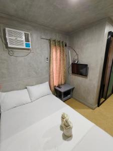 a bedroom with a white bed and a window at FortuneBay Hotel in Tabuelan