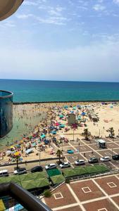 a beach with a lot of people and the ocean at Suite on the beach in Haifa