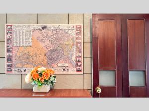 eine Blumenvase auf einem Tisch mit einer Karte in der Unterkunft Retro Saigon Loft - 990 sq ft, heart of D1 in Ho-Chi-Minh-Stadt