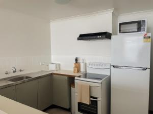 a small kitchen with a stove and a sink at Makai ‘Toward the Sea’ in Port Lincoln