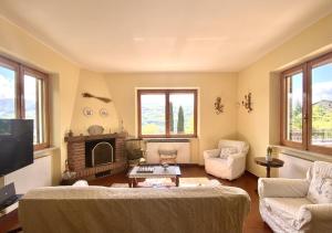 La Casa del Bosco - Villa con vista panoramica su Bobbio e la Val Trebbia في بوبيو: غرفة معيشة مع أريكة ومدفأة