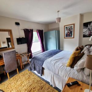 Schlafzimmer mit einem Bett, einem Schreibtisch und einem Fenster in der Unterkunft Stay Norwich Apartments Trade Stay House in Norwich