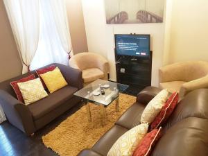 Sala de estar con 2 sofás y TV en Stay Norwich Apartments Pottergate en Norwich