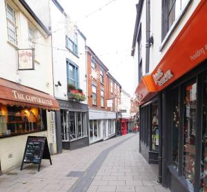 een lege straat in een stad met veel winkels bij Stay Norwich Apartments Pottergate in Norwich