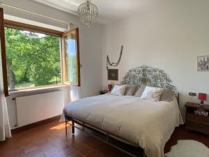 - une chambre avec un grand lit et une fenêtre dans l'établissement La Casa del Bosco - Villa con vista panoramica su Bobbio e la Val Trebbia, à Bobbio