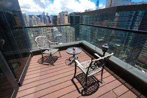 a balcony with two chairs and a table on a roof at Epoch Hotel in Hong Kong