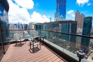 einen Balkon mit 2 Stühlen und Stadtblick in der Unterkunft 盛世酒店 Epoch Hotel in Hongkong