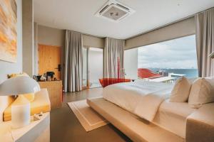 um quarto com uma cama grande e uma janela grande em อาทิตย์ รีสอร์ท เกาะล้าน em Ko Larn