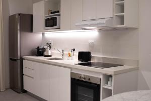 a white kitchen with a sink and a refrigerator at Vizion Juncal- Encanto francés en el corazón de Recoleta- Wifi alta velocidad-Seguridad 24 horas in Buenos Aires +24 photos