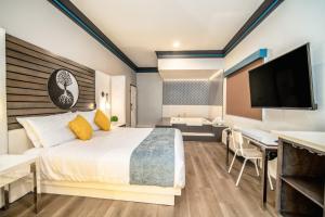 una camera con letto, scrivania e TV di Aspire Inn Studios & Spas a Bellflower