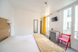 - une chambre avec un grand lit et une chaise rouge dans l'établissement Casa Serena Paris Hôtel, à Paris