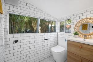 baño blanco con aseo y ventana en Balmain Central Cozy 3 bed house en Sídney