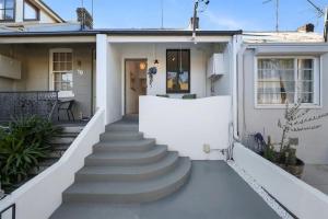 una casa blanca con escaleras que conducen a la puerta principal en Balmain Central Cozy 3 bed house en Sídney