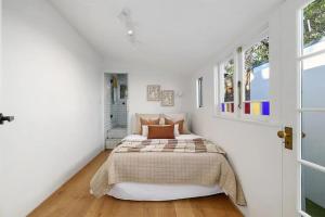 1 dormitorio con 1 cama en una habitación blanca en Balmain Central Cozy 3 bed house en Sídney