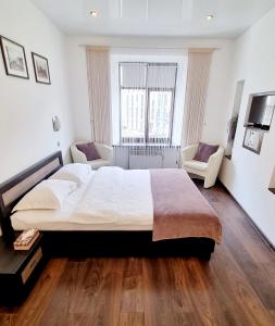 a large white bedroom with a large bed and a couch at Apartment Mitskevycha Square 5 in Lviv