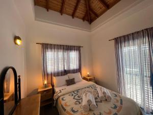 a bedroom with a large bed with two windows at Jomavi Beach Eco-Villa in Polis Chrysochous +70 photos