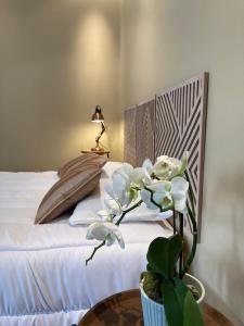 a bedroom with a bed and a table with a plant at Waterlily et Coquelicot house in Vernon