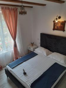 a bed in a bedroom with a large window at PENSIUNEA Bori in Gura Humorului