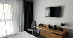 um quarto de hotel com uma secretária e uma televisão na parede em Hotel Igloo em Krotoszyn