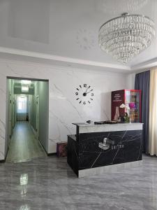 a lobby with a clock on the wall and a desk at Seitek Hotel in Kochkor