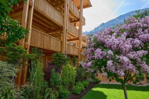 un jardín con flores púrpuras frente a un edificio en Gut Stiluppe - Good Life Hotel, en Mayrhofen