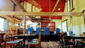 a restaurant with tables and chairs and a bar at Bears House in Furano