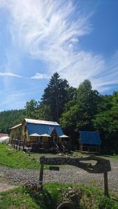 ein großes Haus mit blauem Dach und einem Gebäude in der Unterkunft Bears House in Furano