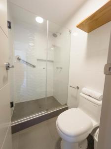 a bathroom with a toilet and a glass shower at Hotel Casa costa in Mollendo +14 photos