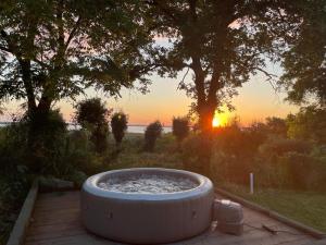 uma banheira de hidromassagem sentada num pátio com o pôr-do-sol em Villa del Monte di Cocco em Lucca