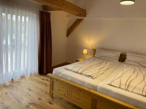 1 dormitorio con cama y ventana grande en Hofgut Breitenbach, en Markdorf