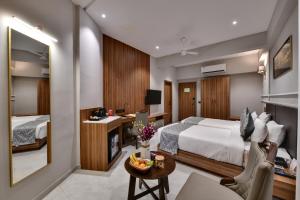 a hotel room with a bed and a desk at Regenta Inn Motikhavdi Jamnagar in Jamnagar