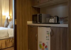 a kitchen with a microwave on top of a refrigerator at Golden Tower Hotel AlKhobar Corniche in Al Khobar