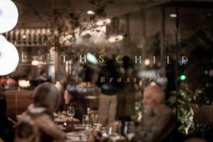 paru ludzi siedzących przy stole w restauracji w obiekcie R48 Hotel and Garden w Tel Awiwie