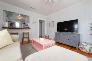 a living room with a couch and a tv at Be A Nomad - Beach Bliss - Close to beach in Jacksonville Beach
