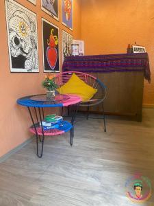 a table with a yellow pillow and a table with a bench at Posada Vs4 Aeropuerto in Mexico City