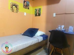 a room with a bed with a desk and pictures on the wall at Posada Vs4 Aeropuerto in Mexico City