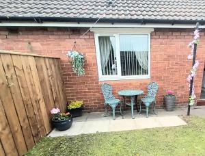 a patio with two chairs and a table and a window at Bungalow in Shildon County Durham in Shildon