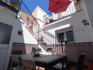 a patio with a table and a red umbrella at Casa Valparaíso Málaga for everybody in Málaga