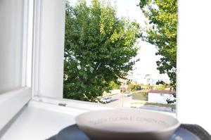 a bowl sitting on a window sill looking out at a tree at 18zero2 luxury rooms in Bari