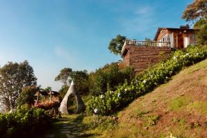 una casa sul fianco di una collina con dei fiori di THỎ NON GARDEN CLOUDY OCEAN VIEW a Blao Srê